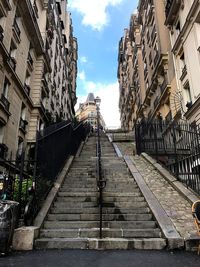 Narrow street amidst buildings in city against sky