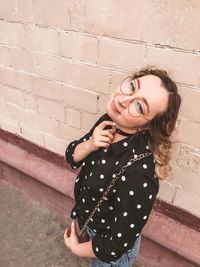 Young woman standing against wall