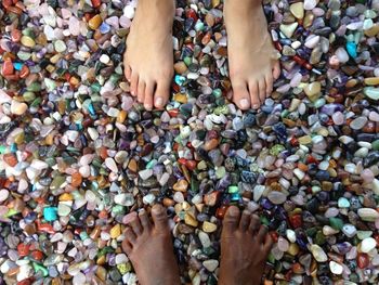 Low section of two people standing on colored stones