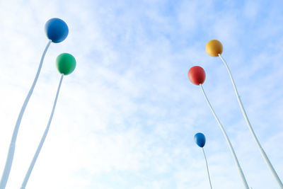 Low angle view of balloons against sky