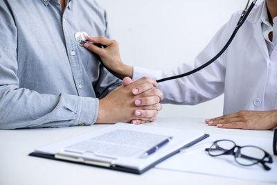 Midsection of doctor examining patient in hospital