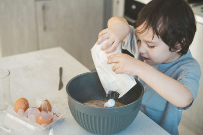 Boy preparing cake in kitchen