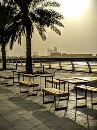 Empty chairs and table by sea against clear sky