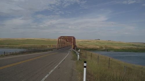 Road by bridge against sky