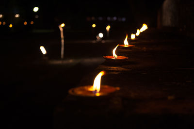 Close-up of lit diyas at night