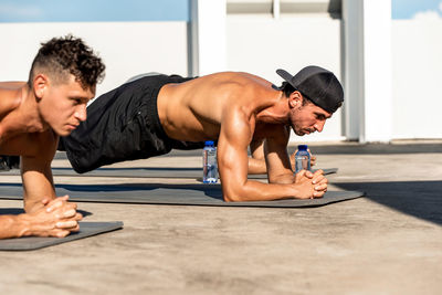 Young shirtless men exercising outdoors