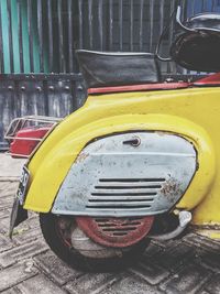 Close-up of yellow car parked on street in city