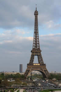 Tower in city against cloudy sky