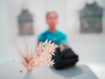 Close-up of woman with flowers on table