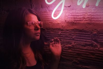 Portrait of woman against illuminated wall