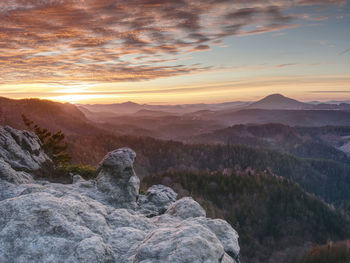 Dreamy beautiful mountain valley with a small hill peaks in the sunset rays