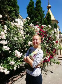 Full length of woman standing by flower tree