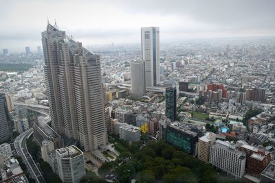 Aerial view of buildings in city against sky