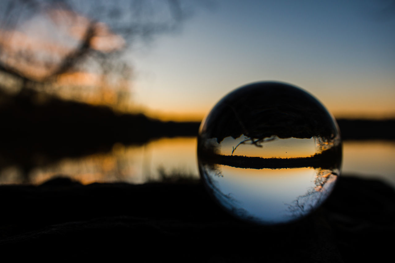 CLOSE-UP OF CRYSTAL BALL ON SILHOUETTE WATER