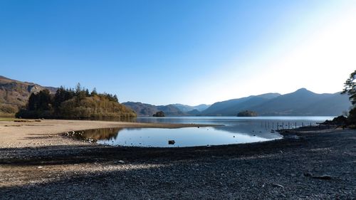 Scenic view of lake against clear blue sky