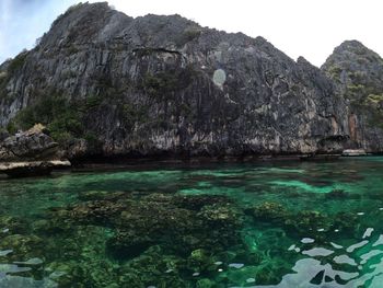 Scenic view of rock formation in sea against sky