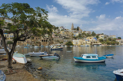 Boats moored in canal by buildings in city