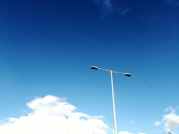 Low angle view of street light against blue sky