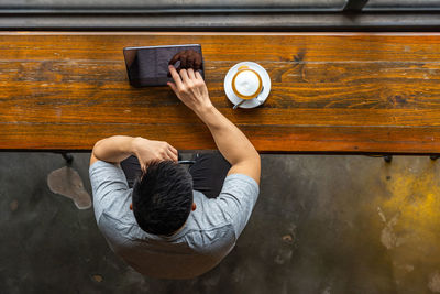 Rear view of man sitting on table