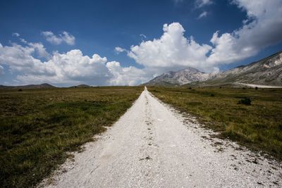 Road amidst green landscape against sky