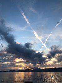 Scenic view of vapor trails in sky during sunset