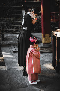 Side view of two women standing on staircase