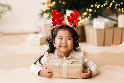 Portrait of an asian emotional little girl child having fun on a christmas holiday in a house