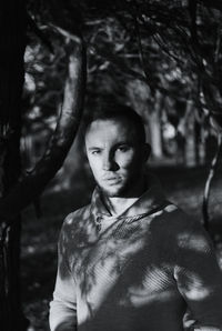 Portrait of woman standing by tree