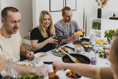 Smiling friends having mexican food at home