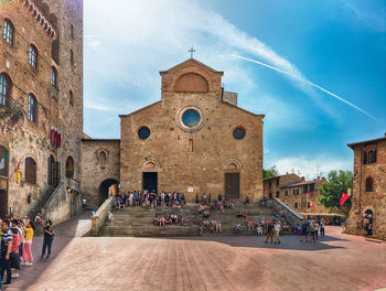 Group of people in historic building against sky in city