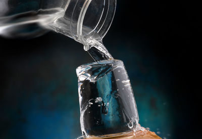 Close-up of glass bottle against black background