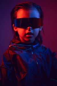 Portrait cyberpunk boy child in vr glasses in blue and red tones. game, virtual reality