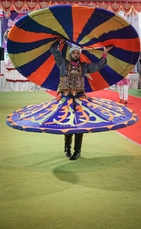 Rear view of woman holding multi colored umbrella