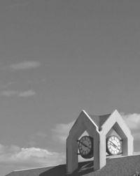 Low angle view of cross against building against sky