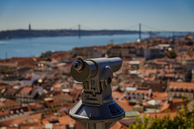 Close-up of coin-operated binoculars against cityscape