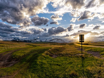 Scenic view of grassy field against cloudy sky