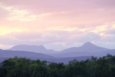 Scenic view of mountain range against cloudy sky