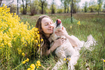 Young beautiful woman and her golden retriever dog having fun in summer