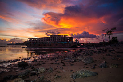 Scenic view of sea against dramatic sky during sunset