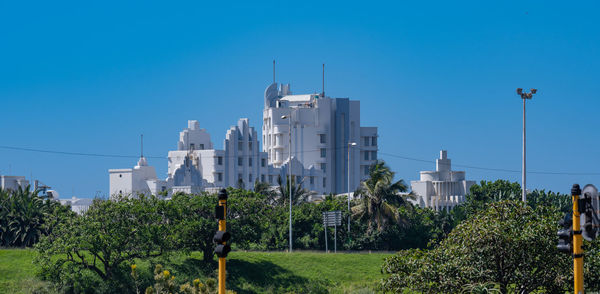 Buildings in city against clear blue sky