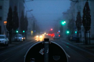 Cars on illuminated road against sky at night