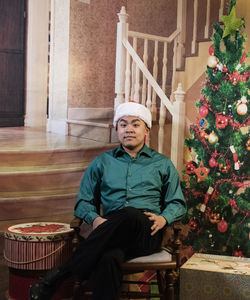 Man sitting by christmas tree