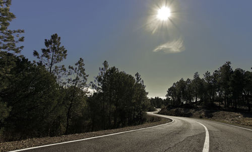 Road amidst trees against clear sky