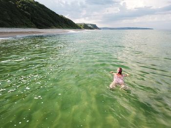 High angle view of woman swimming in sea