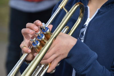 Midsection of woman playing musical instrument