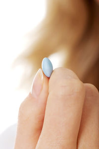 Cropped image of woman holding pill 