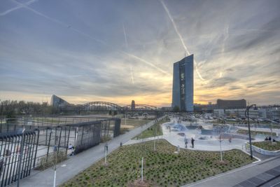 Bridge over river in city at sunset