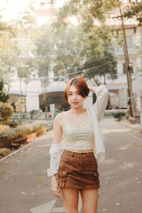 Side view of young woman standing in city