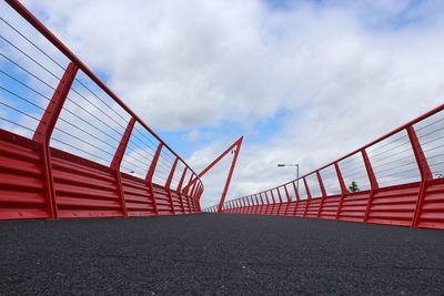 Red bridge against cloudy sky