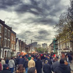 Buildings in city against cloudy sky